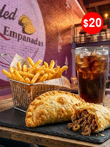 Two empanadas, one cut open, with a basket of seasoned fries and an iced soft drink, the daily $20 lunch special