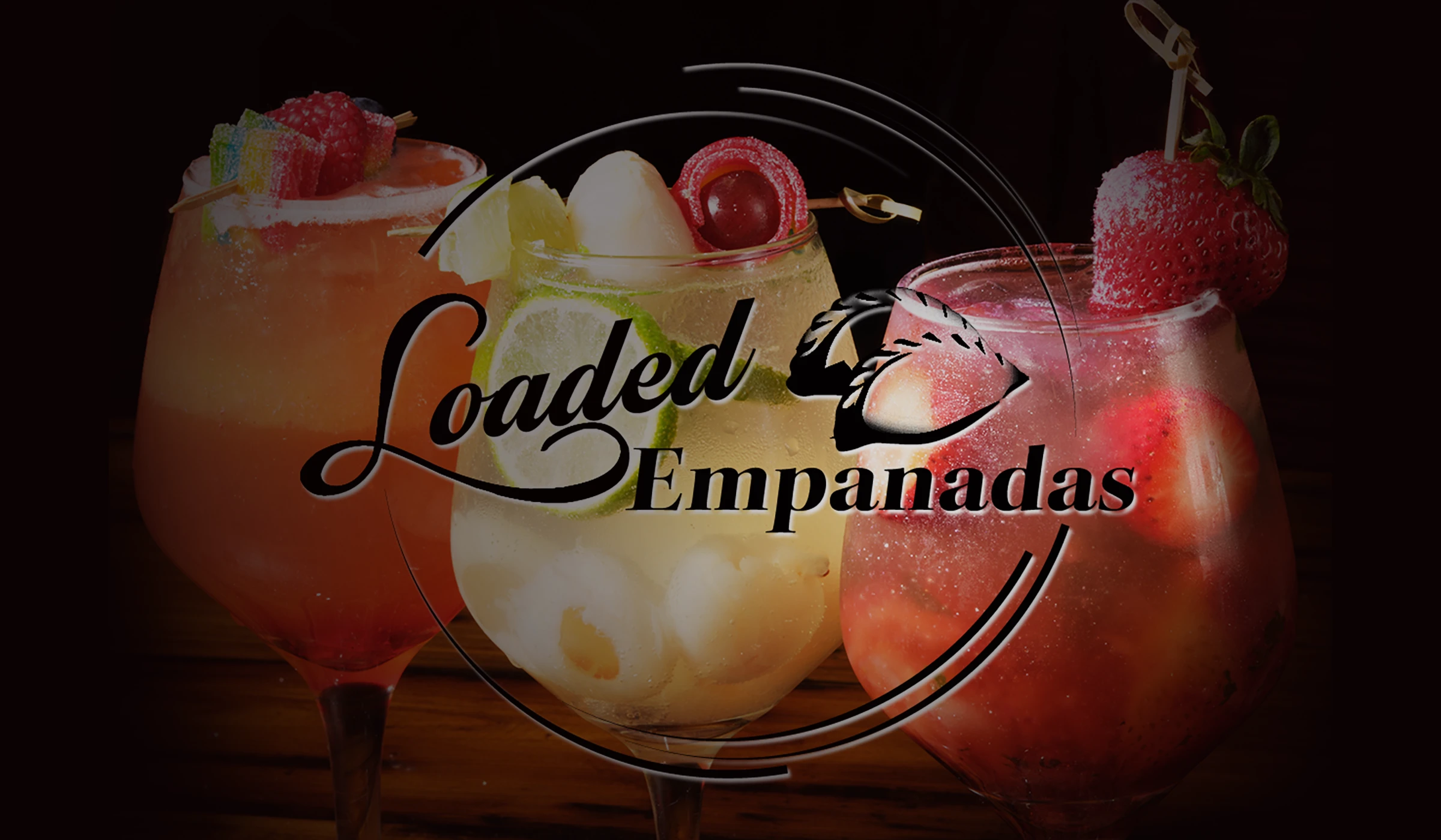 Three glasses of house-made sangria loaded with lychee, strawberry and citrus on the bar at Loaded Empanadas